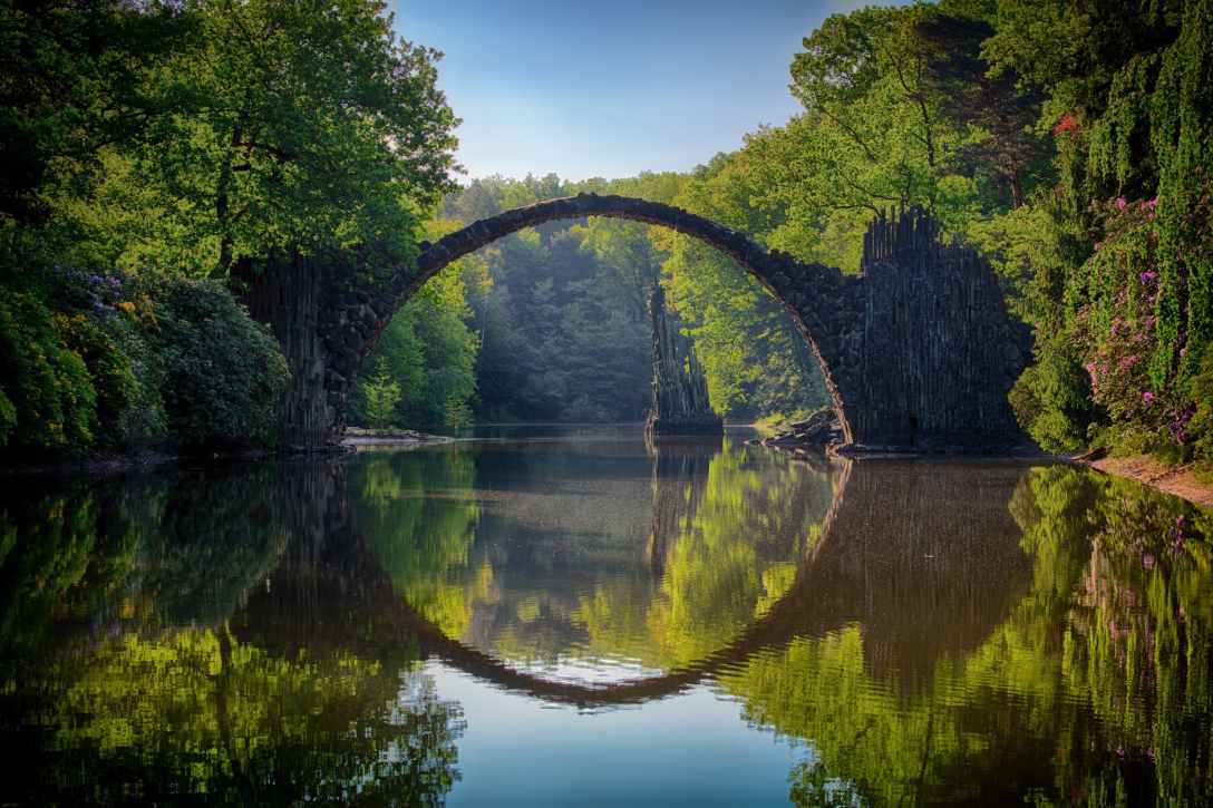 broken bridge reflected in river